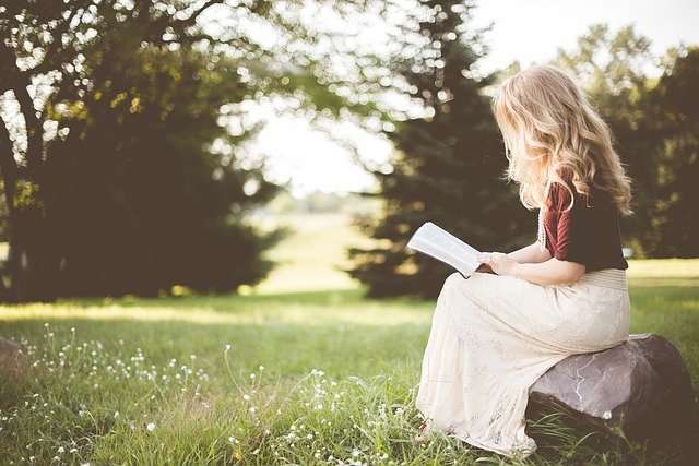 woman reading book in nature